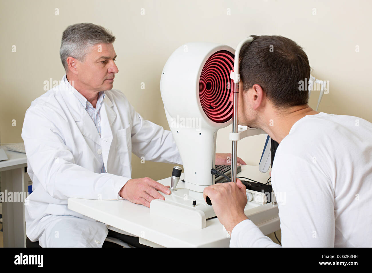 Man having his eyes examined by an eye elderly doctor. Stock Photo