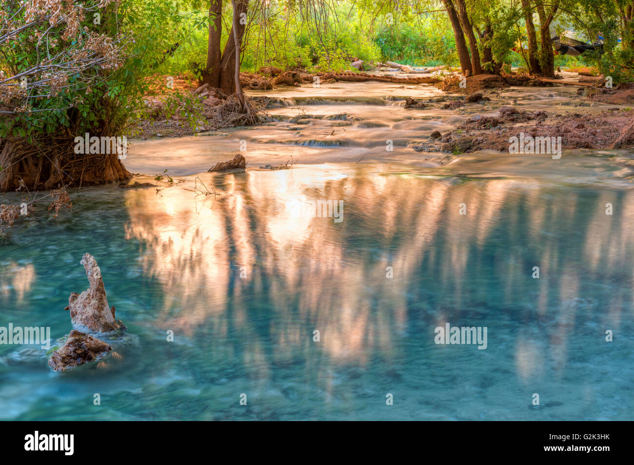 Sunlight bounces off the cliffs and lights up reflections in Havasu Creek on Havasupai Indian Reservation in the Grand Canyon Stock Photo