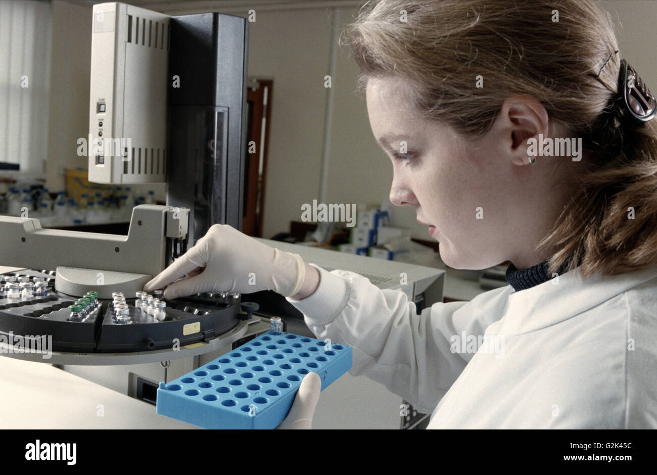 Technician loads urine samples into machine for drug testing Stock ...