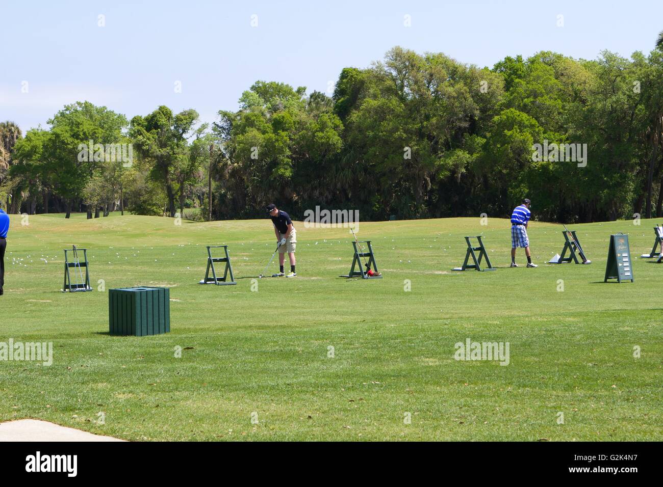 Golfers on a driving range Stock Photo