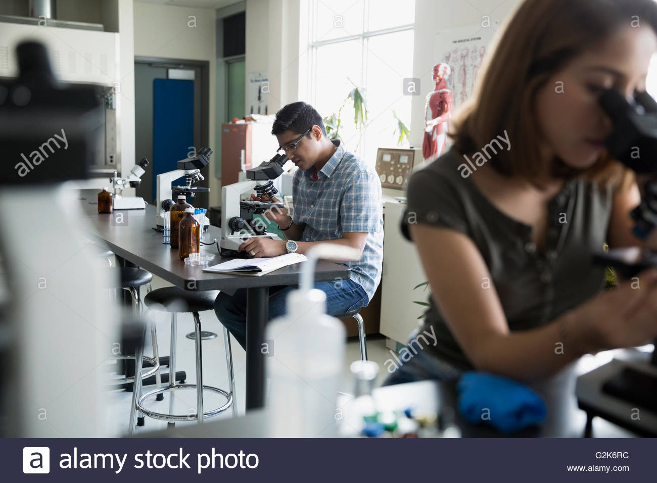 College student using microscope in science laboratory Stock Photo