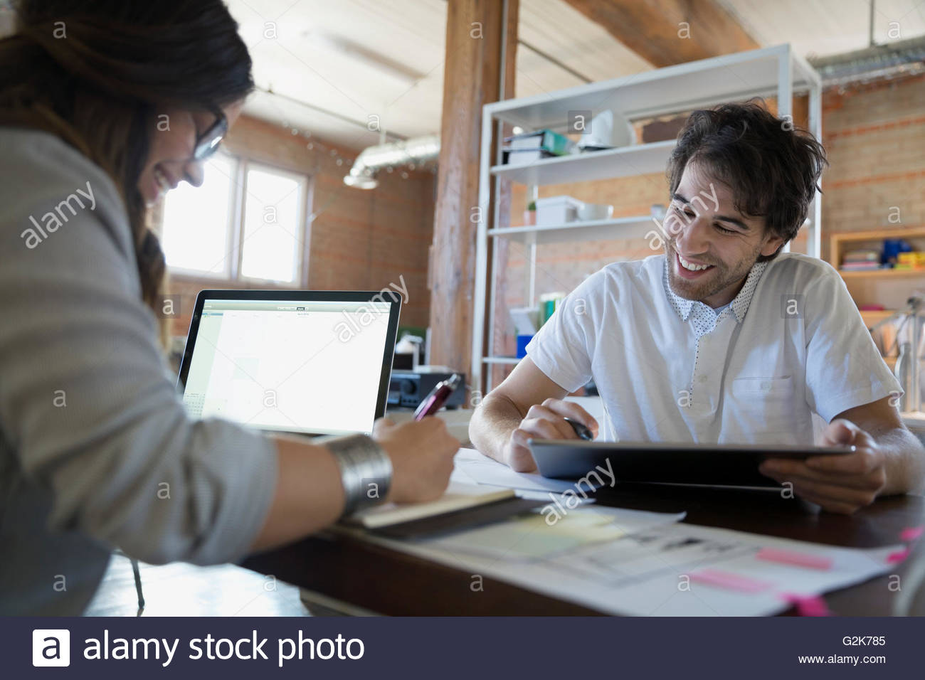Designers with laptop and digital tablet discussing plans in office Stock Photo