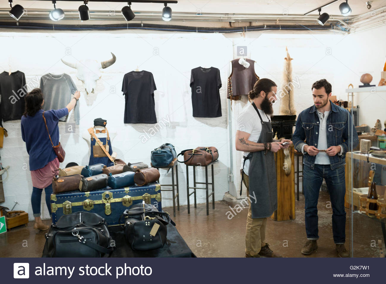 Leather shop owner assisting customer Stock Photo