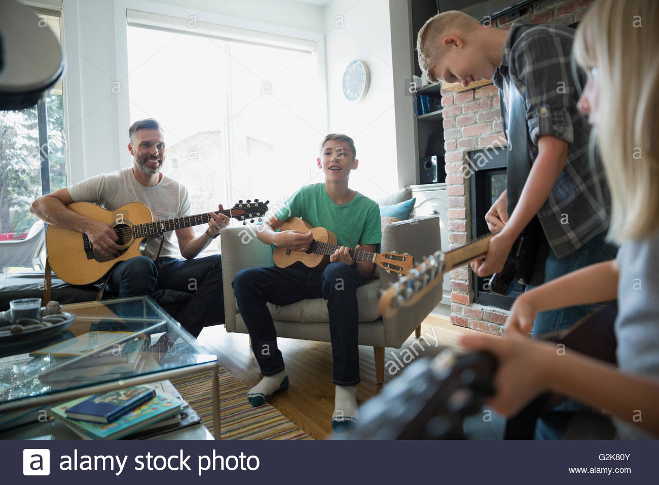 Family playing guitars in living room Stock Photo
