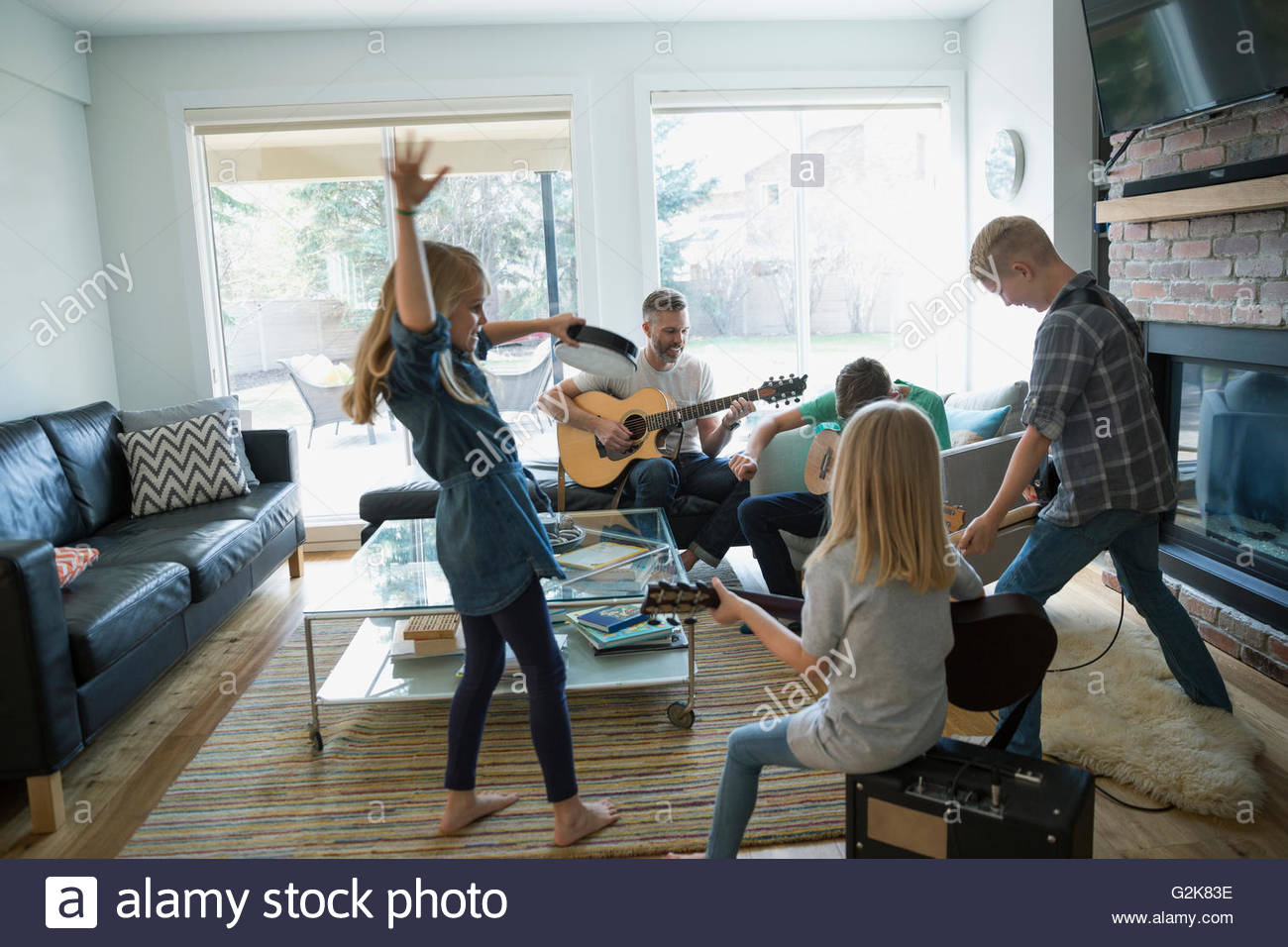 Family playing guitars and dancing in living room Stock Photo Alamy