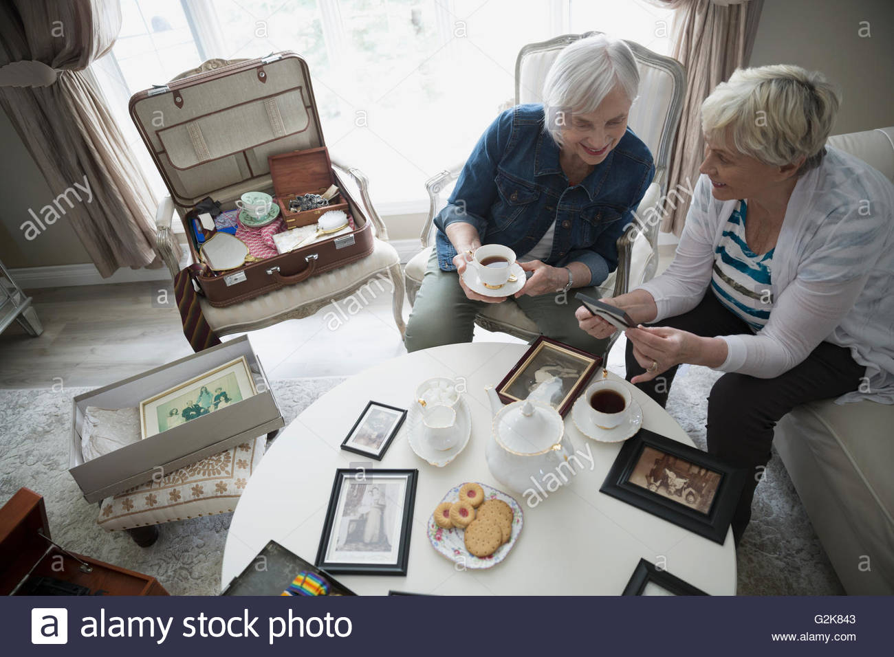 Senior women drinking tea and looking at old photographs Stock Photo ...