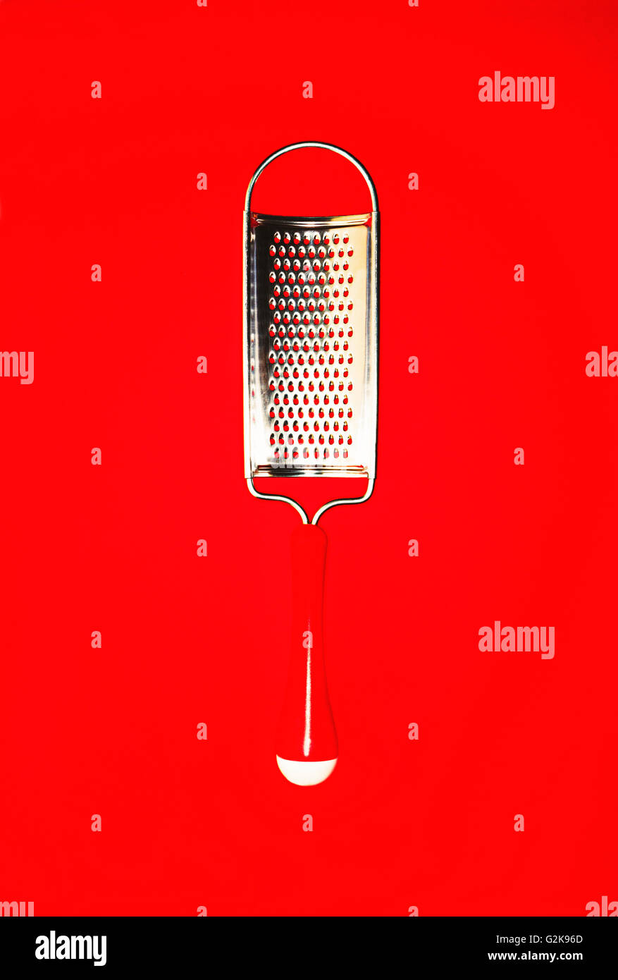 small metal grater on a bright red background Stock Photo