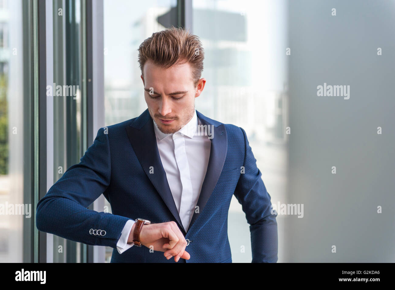 Portrait of young man wearing suit checking the time Stock Photo - Alamy