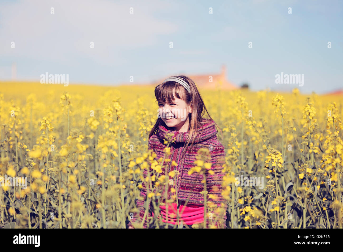 Portrait of little girl standing in front of rape field Stock Photo - Alamy
