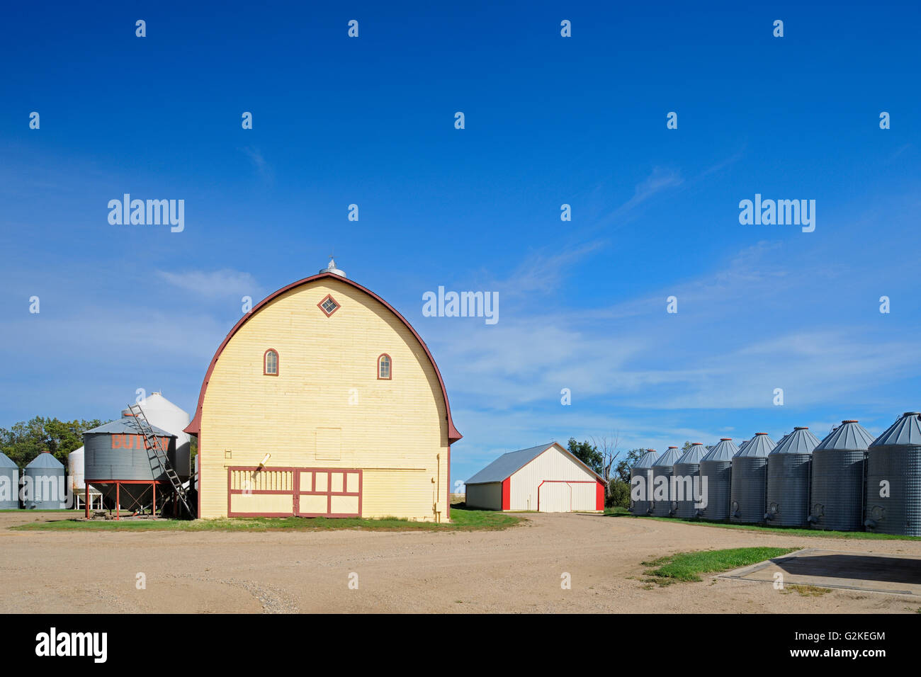 Yellow barn & Grain bins in farmyard - Property Released Yellow Grass Saskatchewan Canada Stock Photo