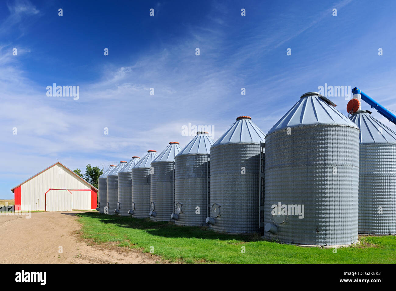 Grain bins and auger in farmyard - Property Released Yellow Grass Saskatchewan Canada Stock Photo