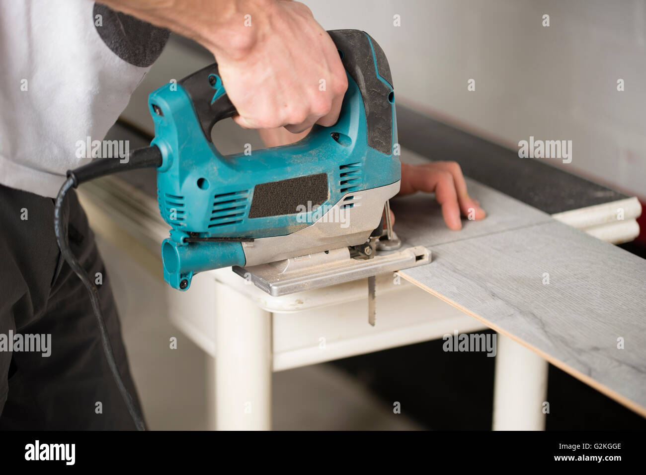 Man cutting laminate floor pieces with a jigsaw Stock Photo Alamy