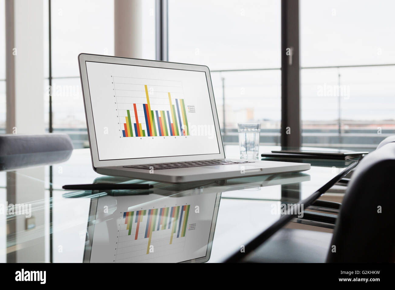 Laptop with bar chart on office desk Stock Photo
