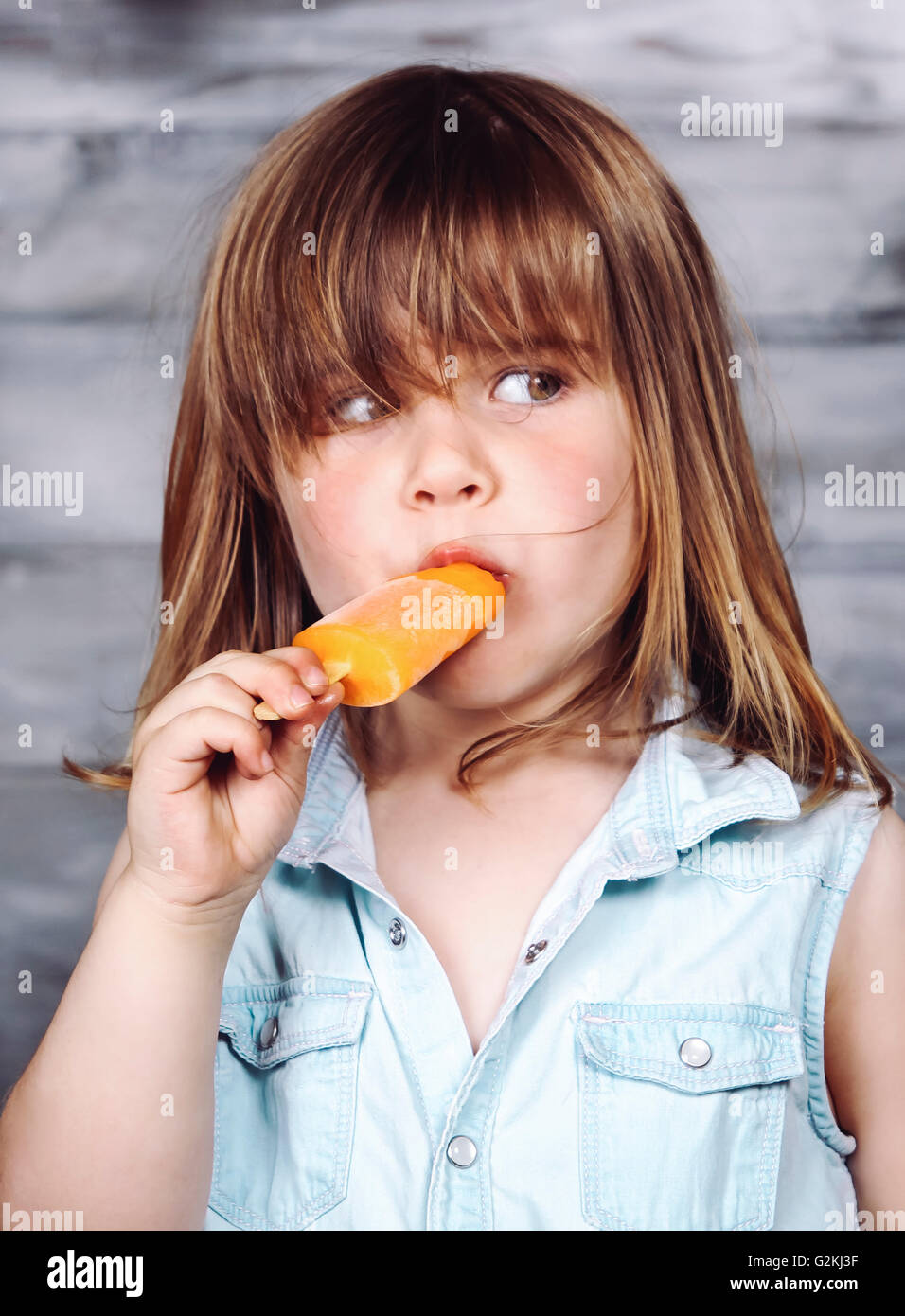 Portrait of little girl eating ice lolly Stock Photo Alamy