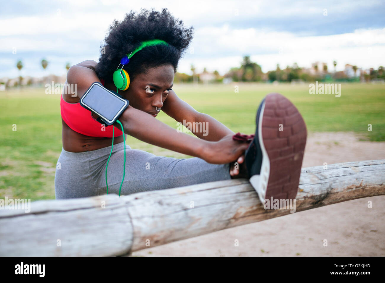 ng black athlete listening music with headphones while warming up Stock Photo