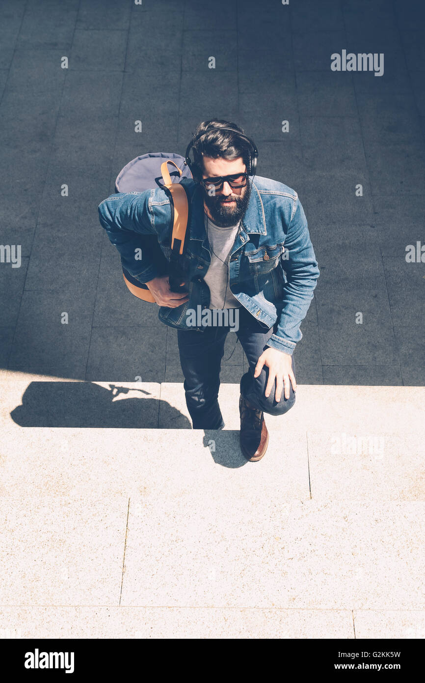 Young man with headphones climbing the big stairs Stock Photo Alamy
