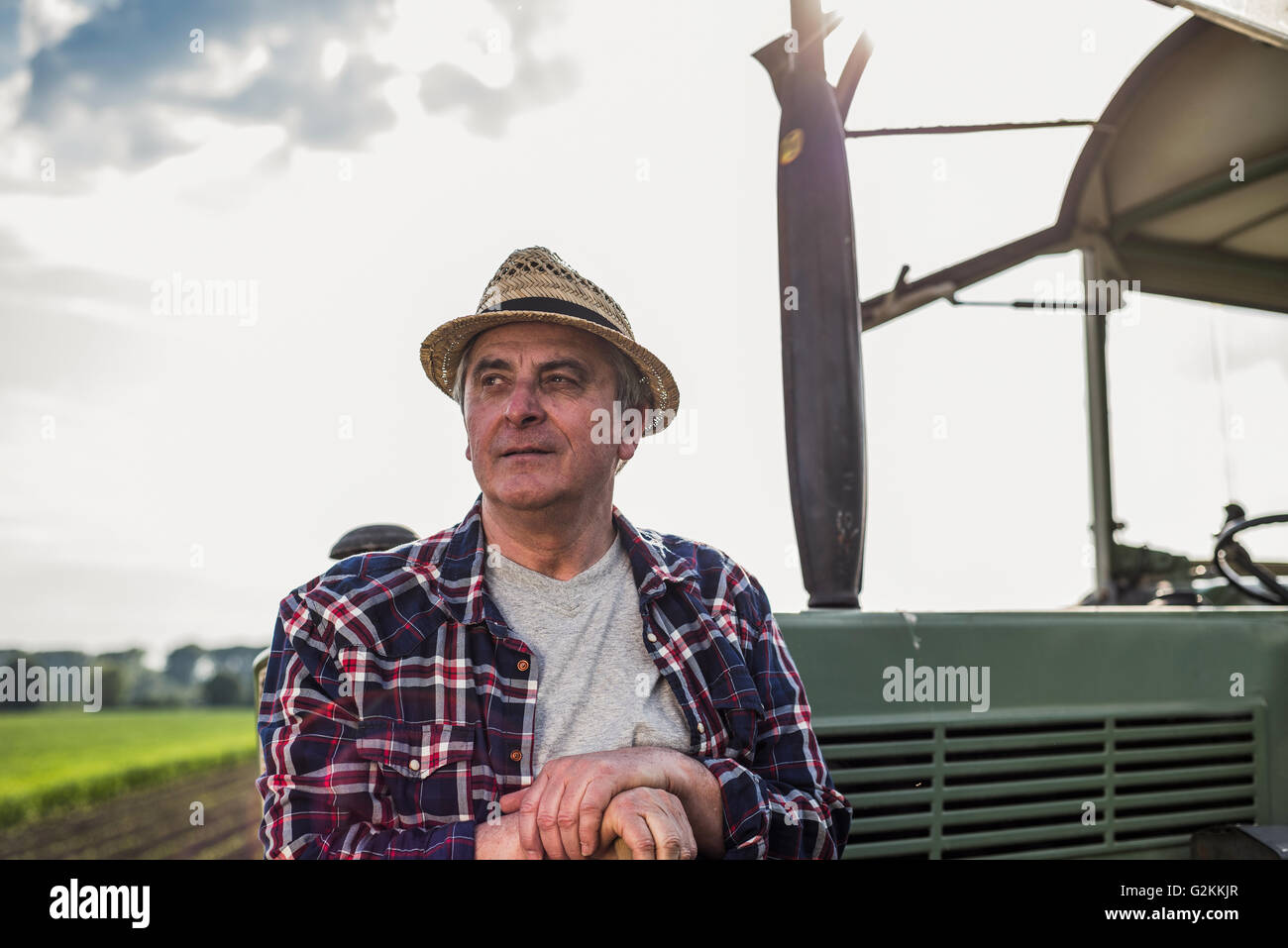 Farmer standing at tractor Stock Photo - Alamy
