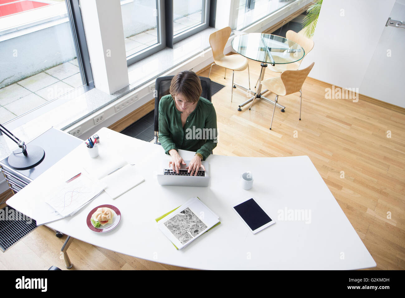 Businesswoman using laptop at office desk Stock Photo