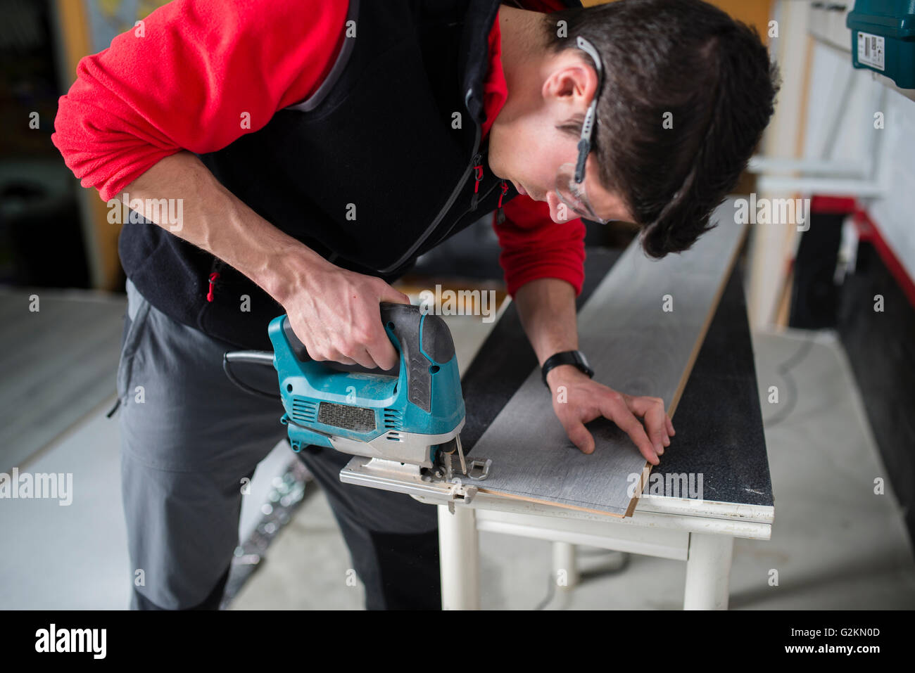 Man cutting laminate floor pieces with a jigsaw Stock Photo Alamy