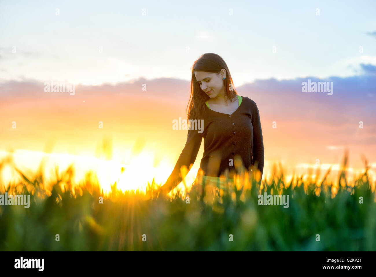 Beauty Girl Outdoors enjoying nature. Beautiful Teenage Model girl in white dress running on the Field, Sun Light. Glow Sun Stock Photo