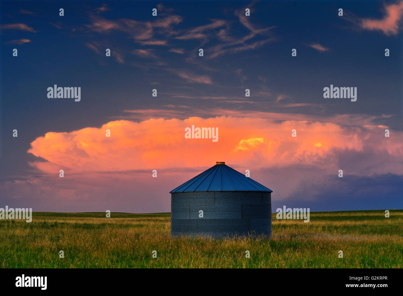 pink clouds at sunset with grain bin and storm sky Bengough Saskatchewan Canada Stock Photo