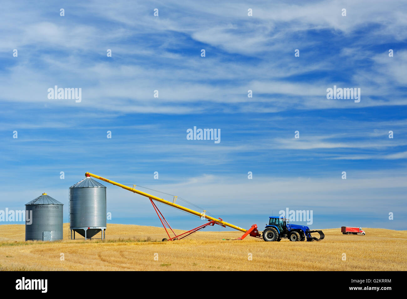 Grain bins, tractor and auger near Beechy Saskatchewan Canada Stock Photo