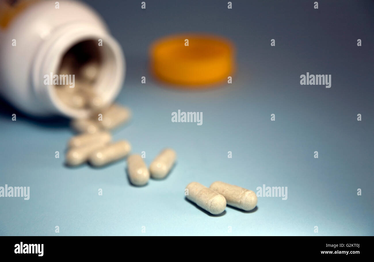 Vitamin Capsules Spilling out of Container Stock Photo