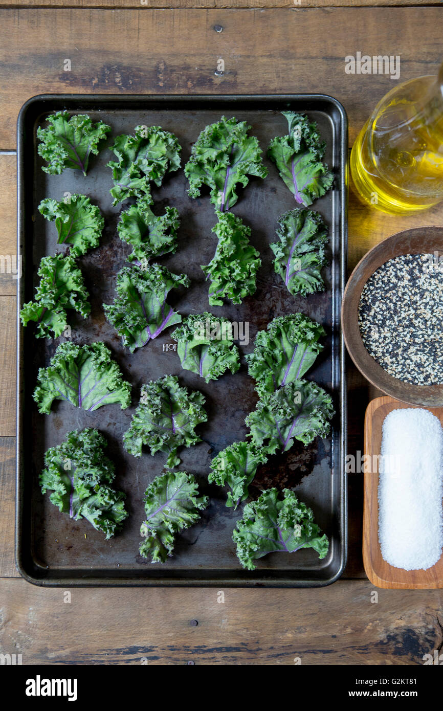 Kale Leaves on Baking Tray Being Prepared for Oven Stock Photo