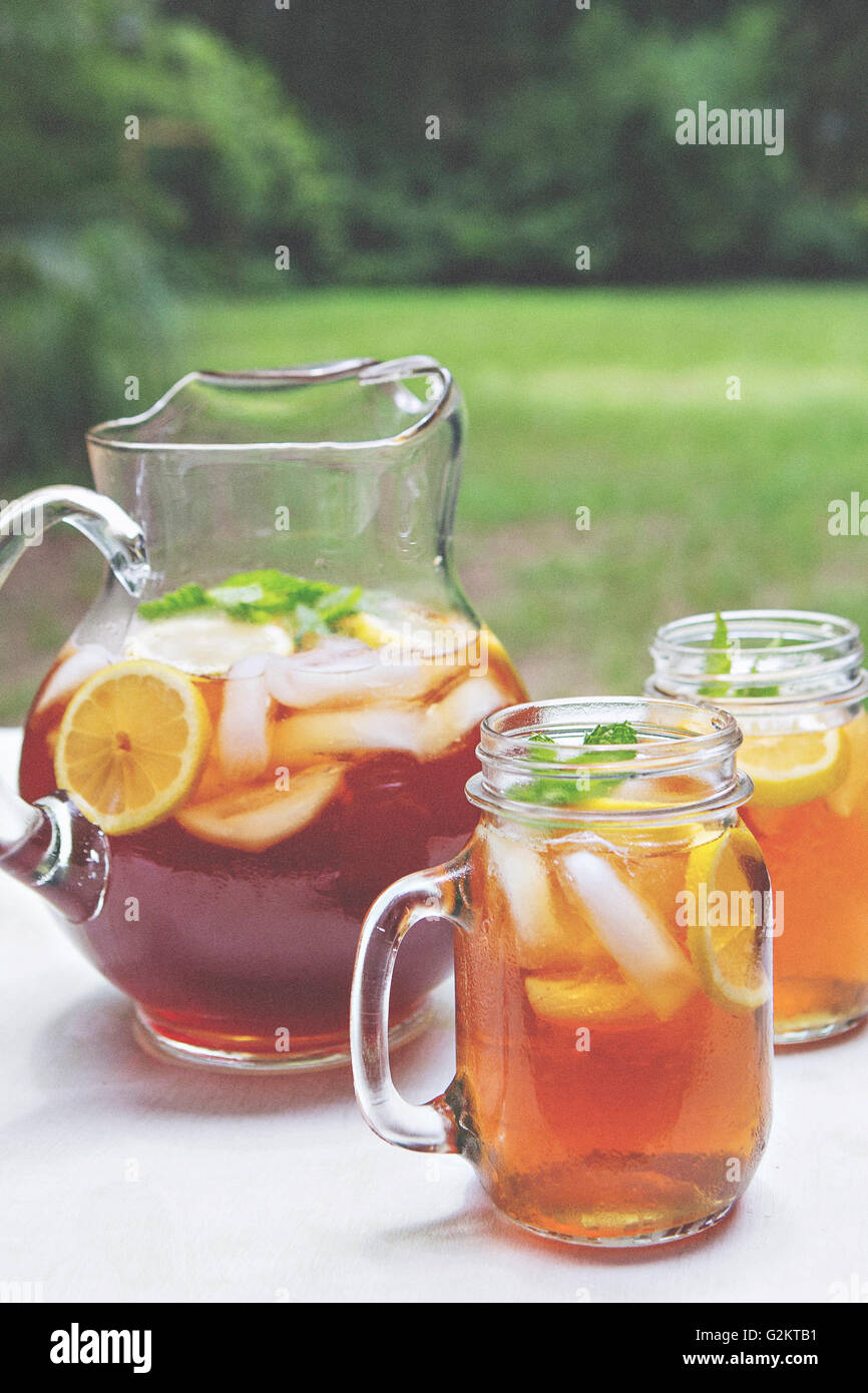https://c8.alamy.com/comp/G2KTB1/iced-tea-in-pitcher-and-glass-mugs-with-lemon-and-mint-G2KTB1.jpg