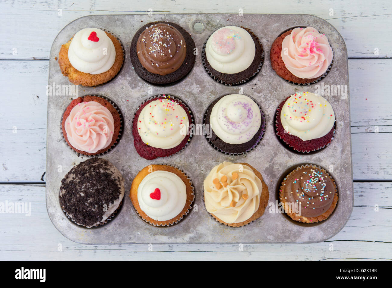 Assortment of Frosted Cupcakes in Cupcake Tin, High Angle View Stock