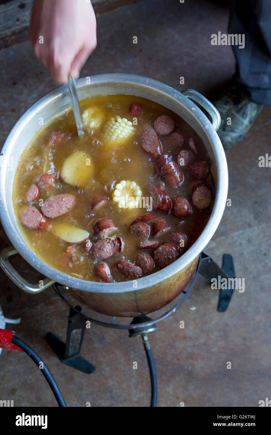 Person Cooking Low Country Boil with Corn and Sausages Stock Photo
