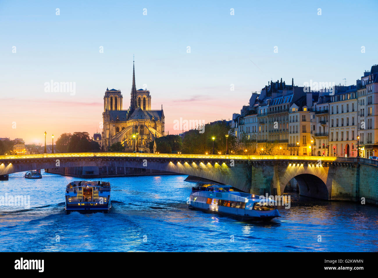 Paris, Tour boat on the Seine river at sunset with Notre Dame de Paris Cathedral in Background Stock Photo