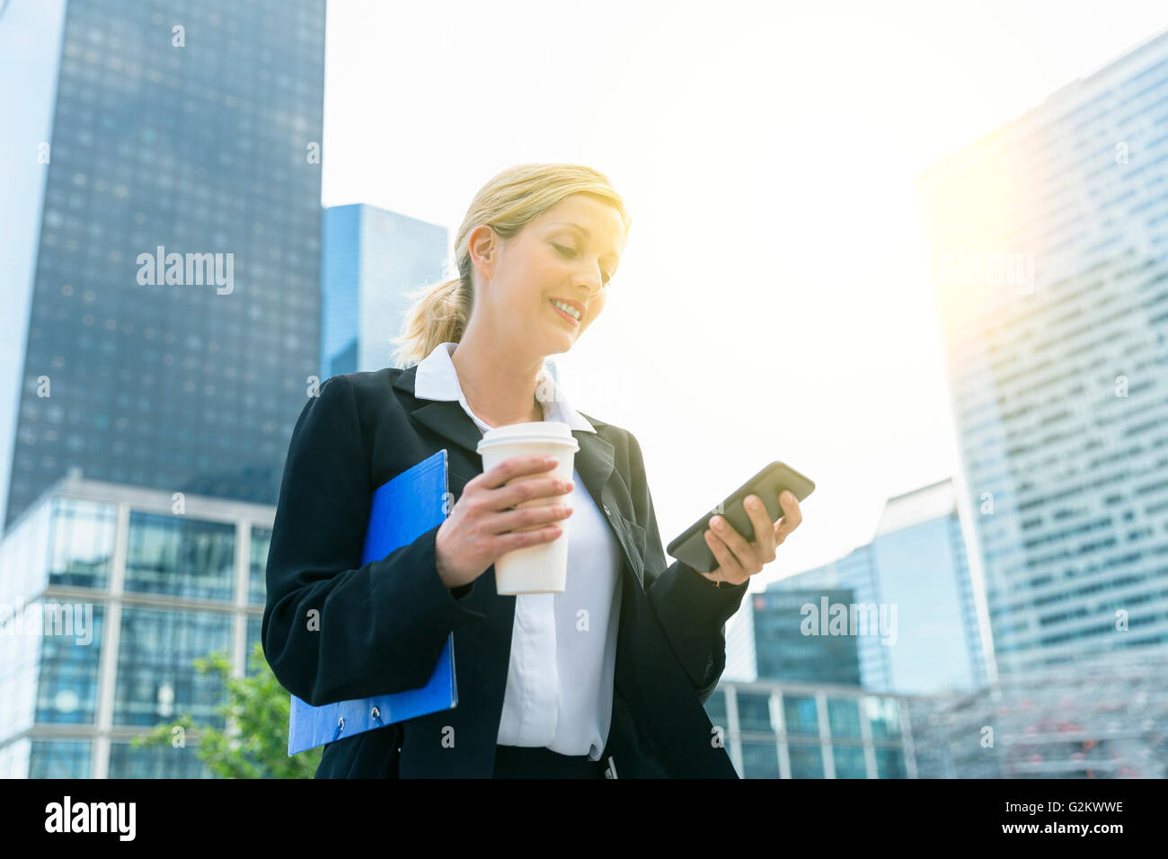 Businesswoman text messaging in financial district Stock Photo