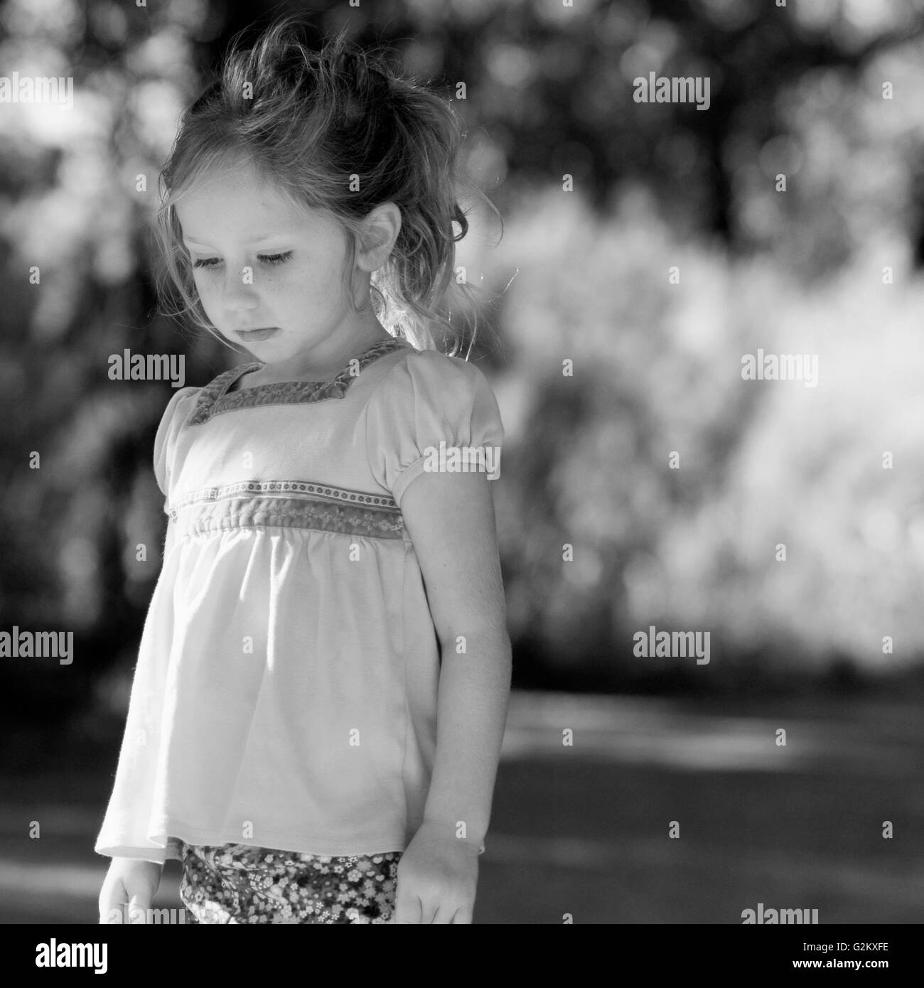 Little Girl Looking Down Outside Stock Photo - Alamy