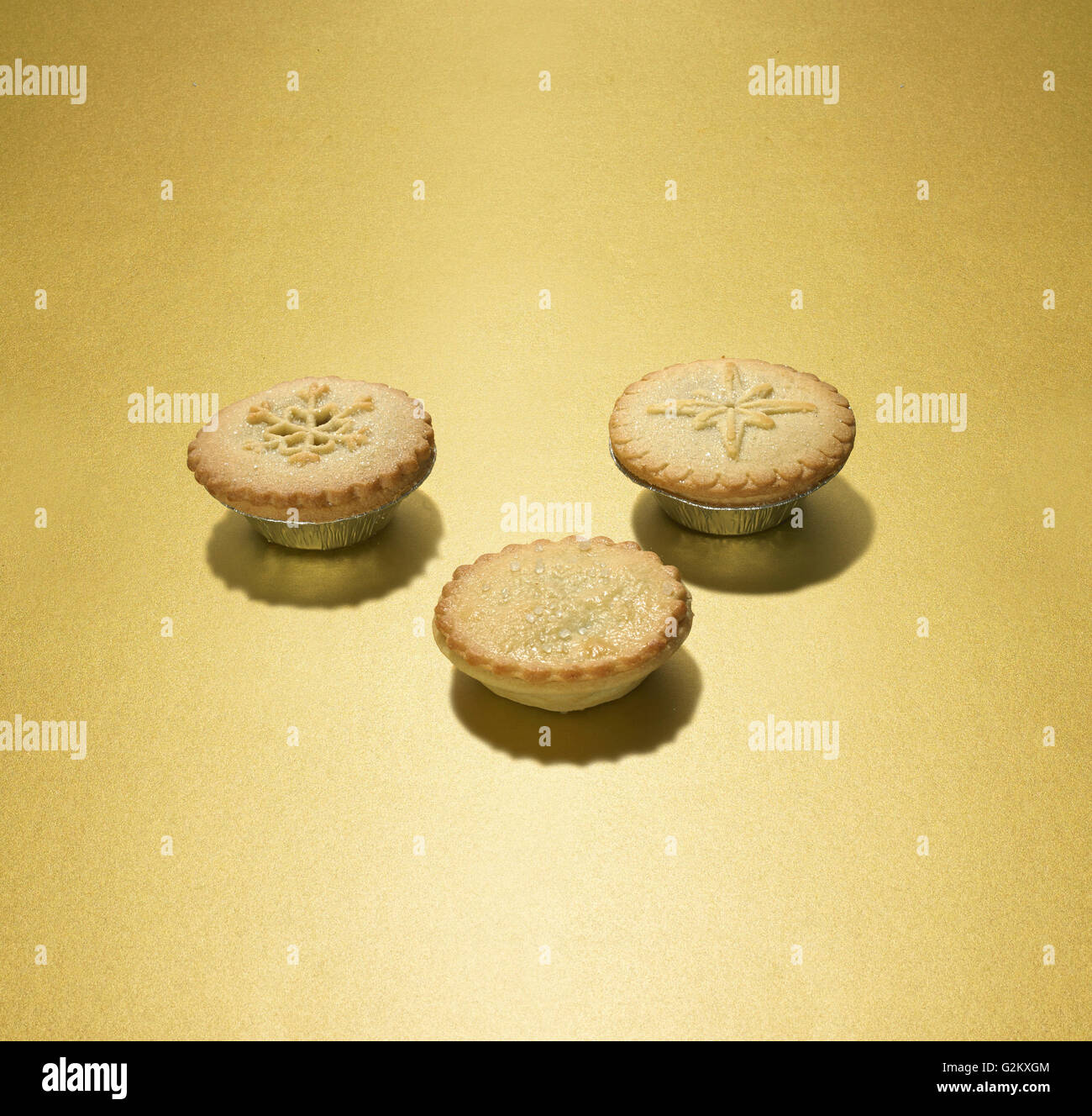 3 mince pies on a gold background Stock Photo