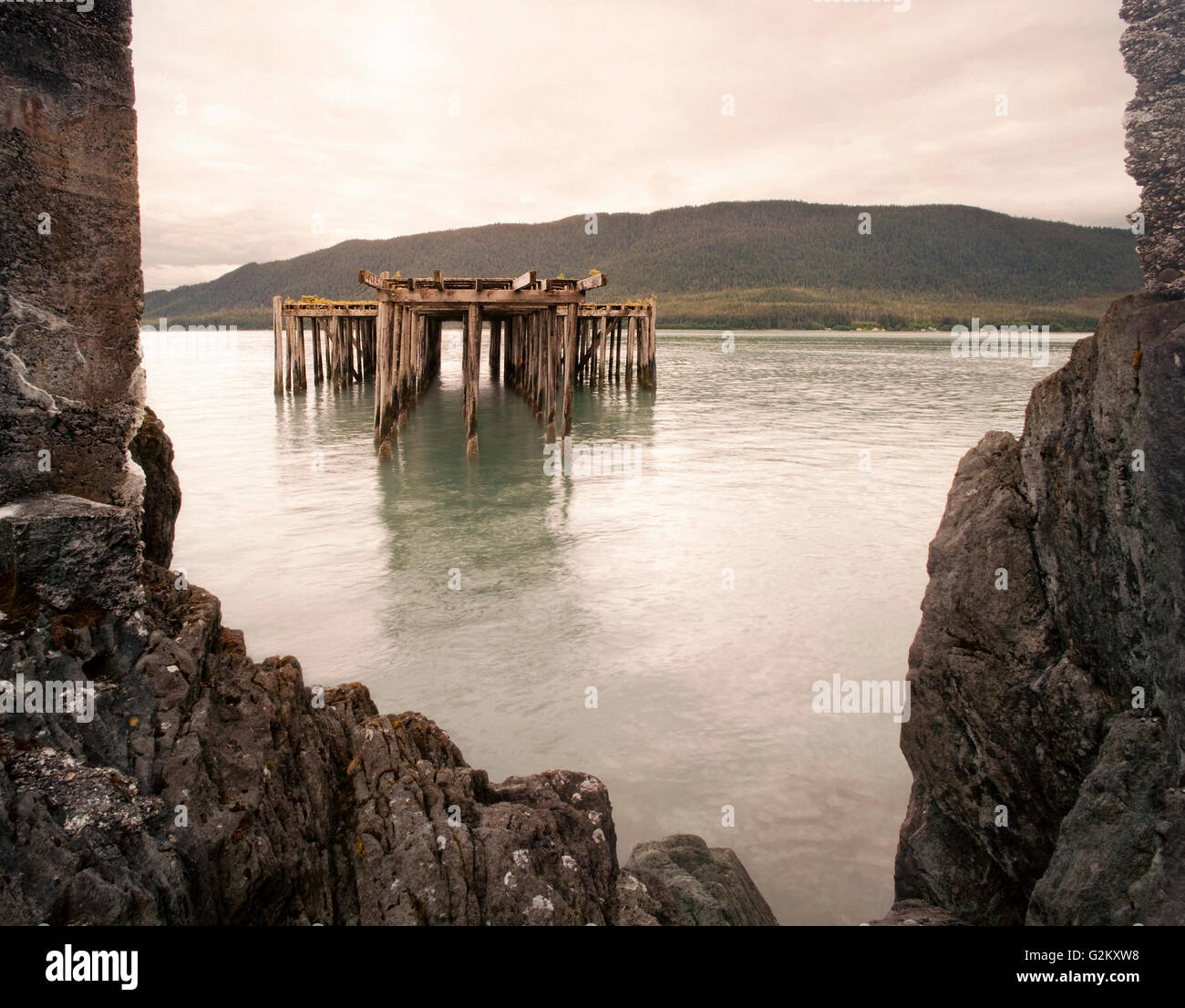 Old Fishing Pier Viewed Though Sea Wall Opening, Juneau, Alaska, USA Stock Photo
