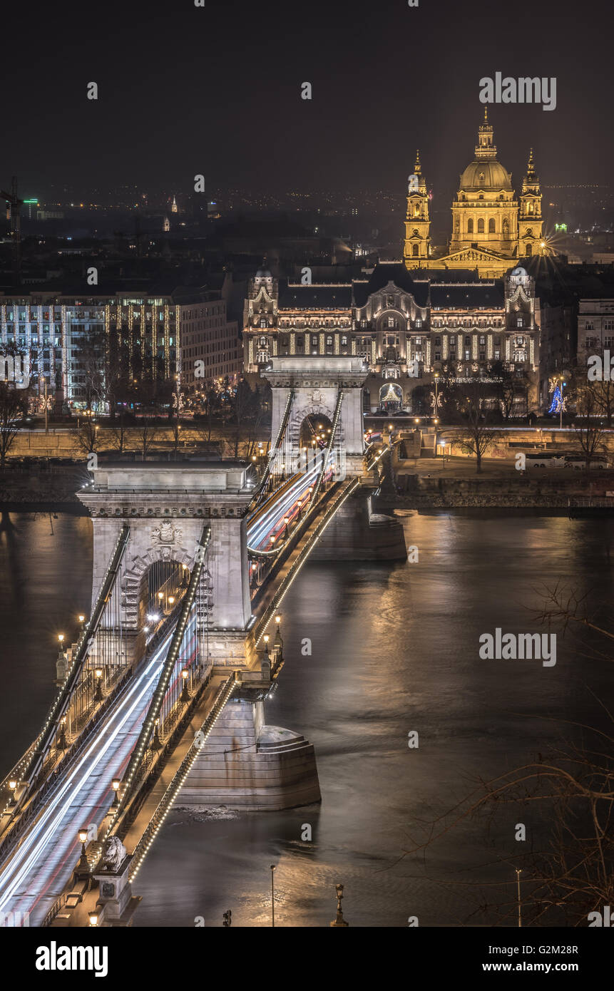 Night View of Chain Bridge over Danube River and St. Stephen's Basilica in Budapest, Hungary. As Seen from Royal Palace in Buda Stock Photo