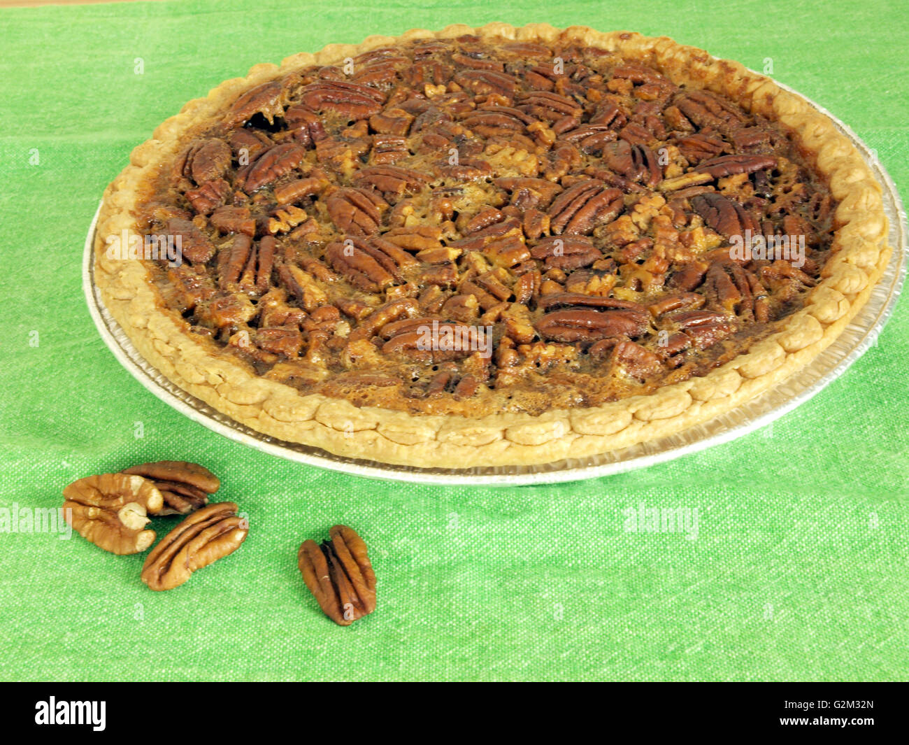 image of homemade pecan pie on a green table cloth Stock Photo