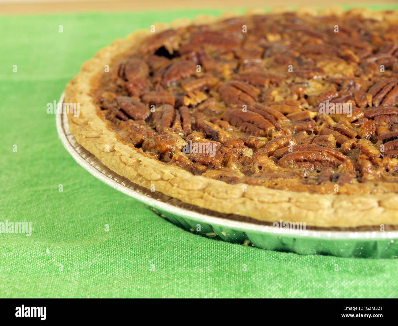 close up image of homemade pecan pie on a green table cloth Stock Photo