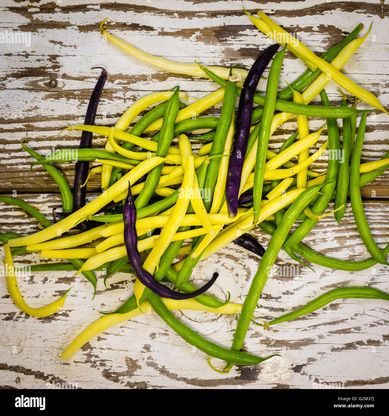 organic multicolored string beans on an old table Stock Photo