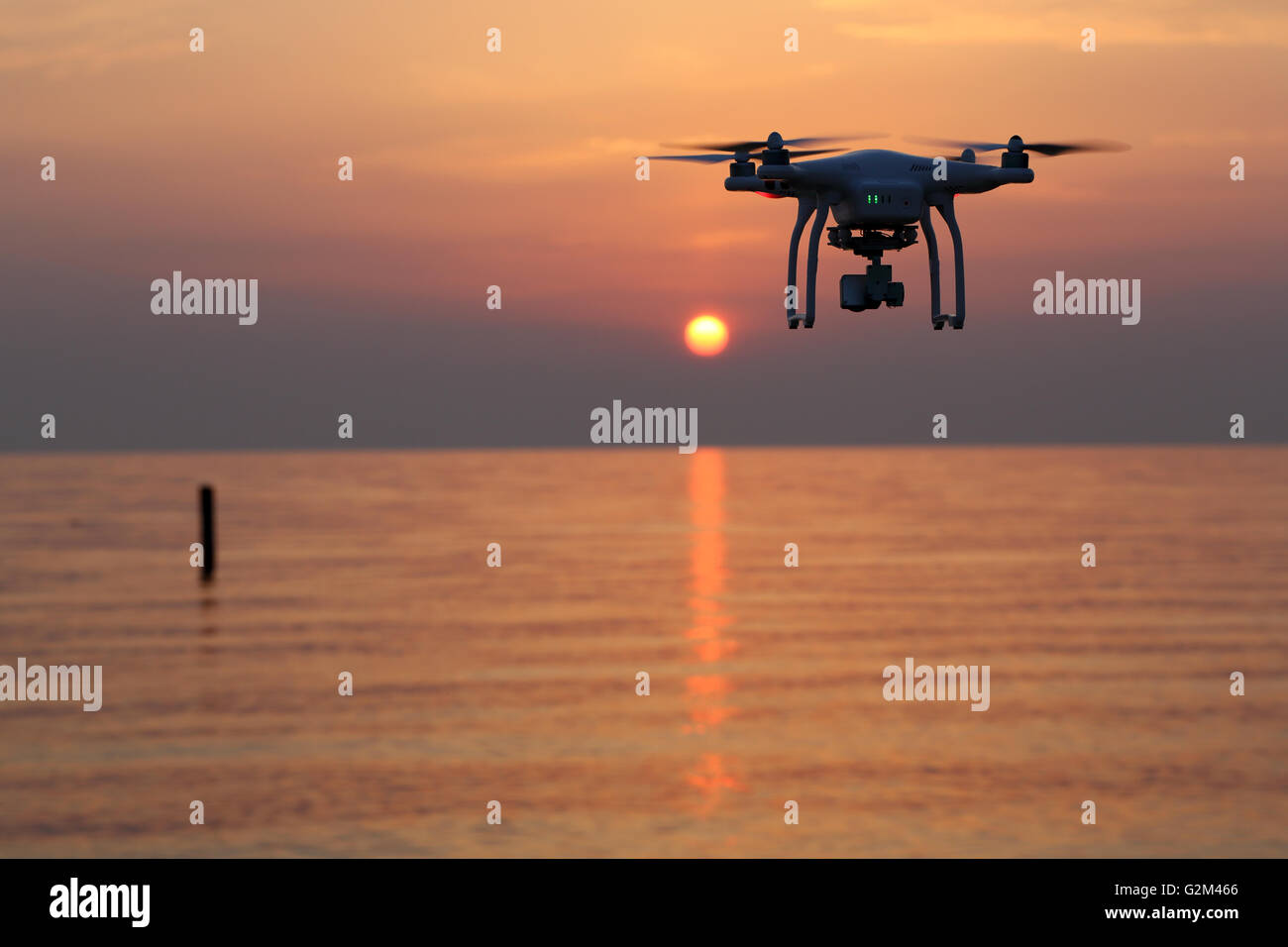 Drone flying against a sunset sky Stock Photo - Alamy