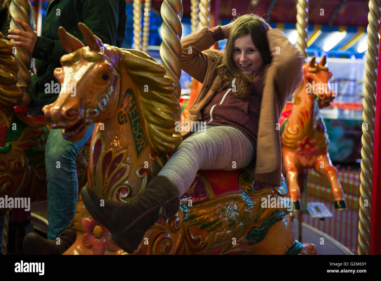 Model released image of a young girl riding on a Merry-go-Round at Southsea, Portsmouth, Hampshire, UK Stock Photo