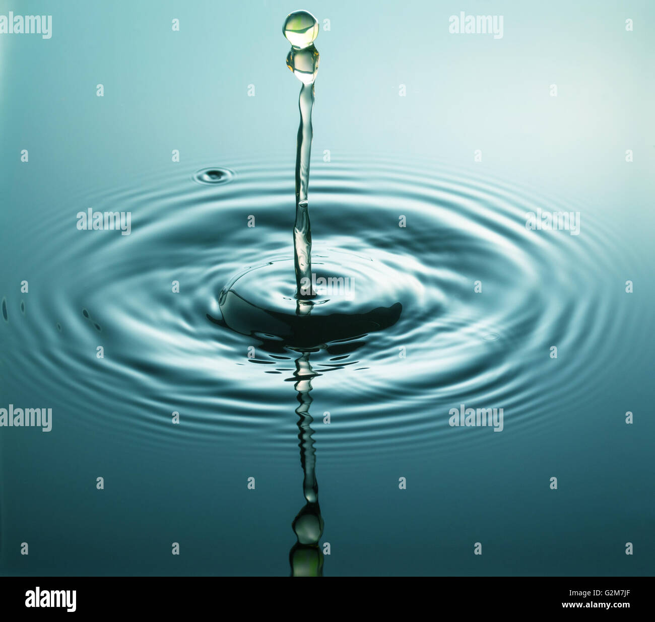 Water drop photography, one or two drops of water dropped from height into water and captured as they hit the water or collide Stock Photo