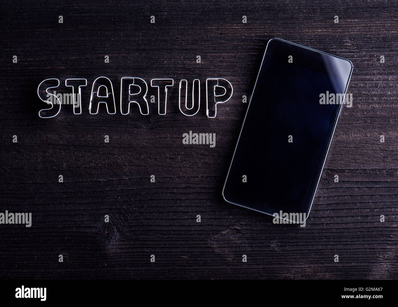 Smart phone and start up sign made of cookie cutters. Studio shot on ...