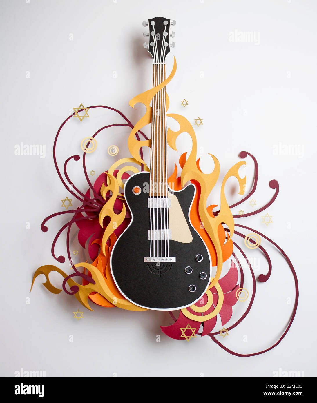 Stars and swirls surrounding paper craft guitar Stock Photo