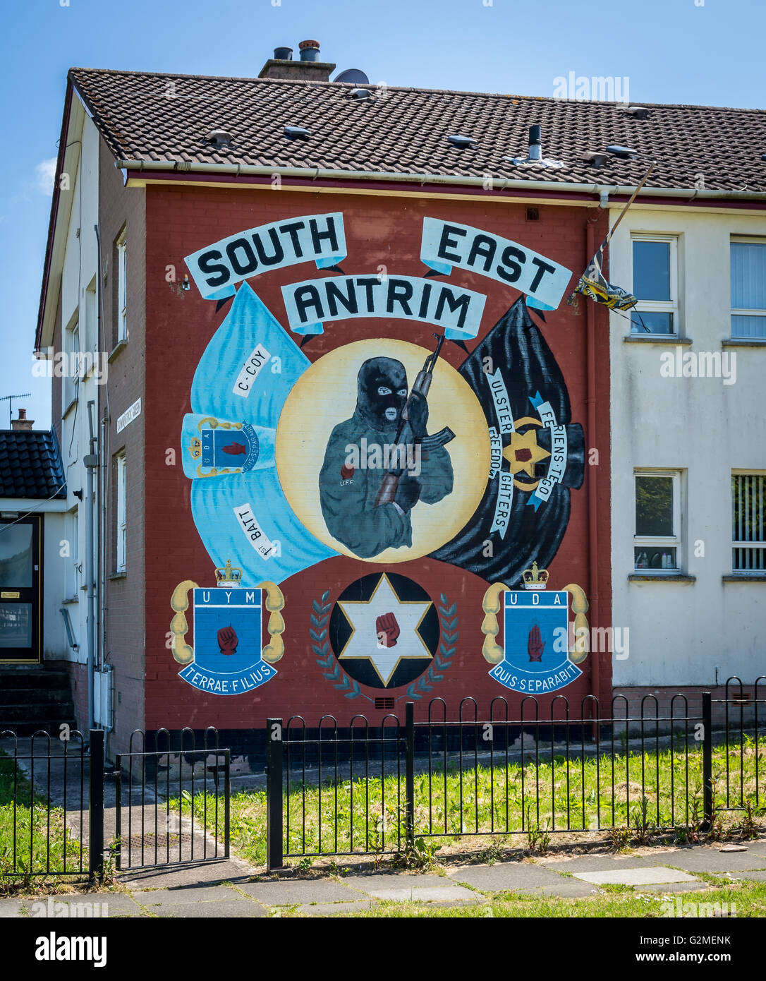 South East Antrim UDA UFF mural in Monkstown estate depicting masked, armed Loyalist gunman holding AK47 weapon. Stock Photo