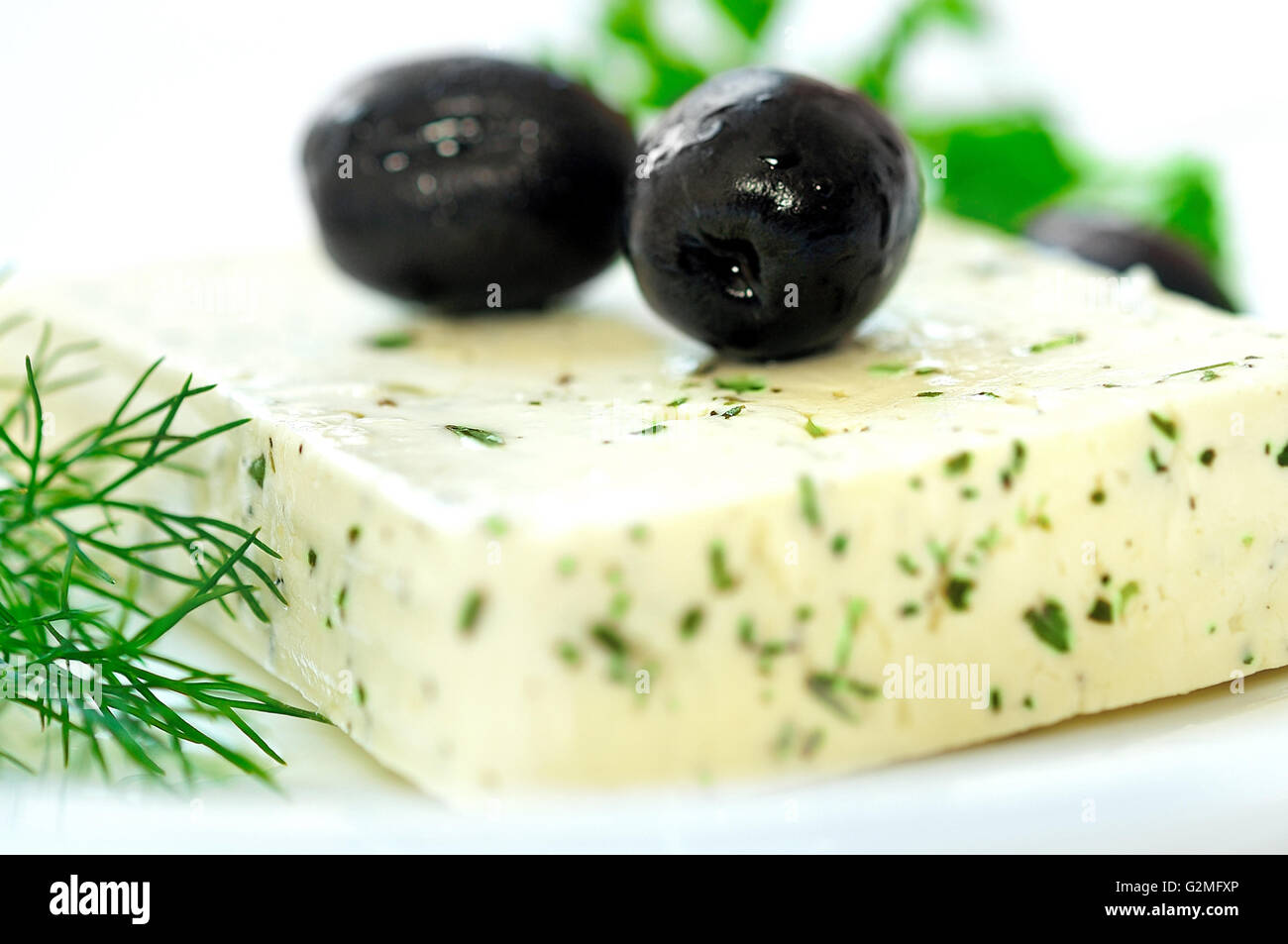 Cheese with herbs on table Stock Photo