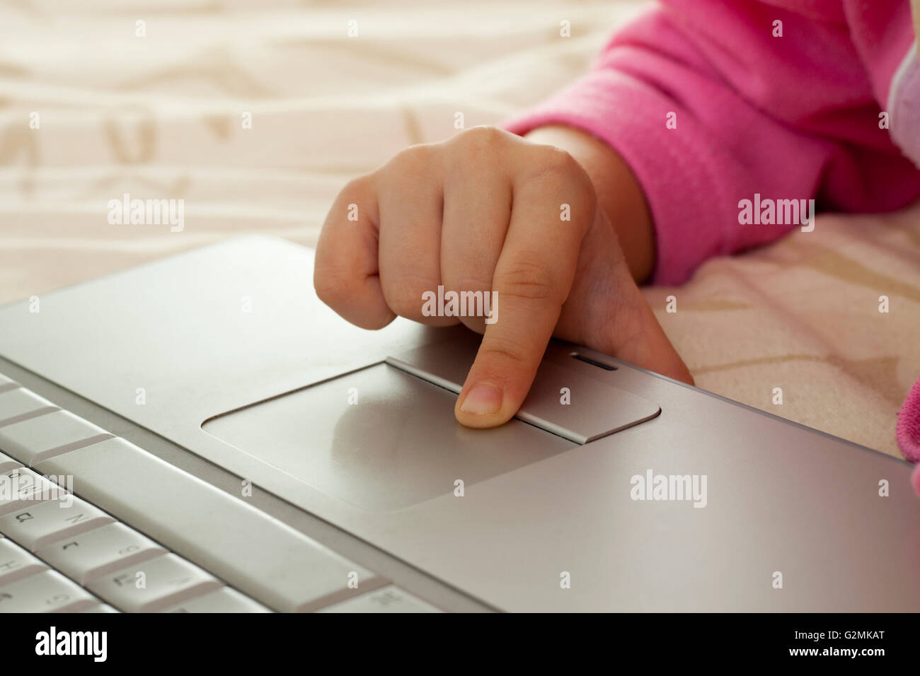 little girl fingers on a silver laptop's trackpad Stock Photo Alamy