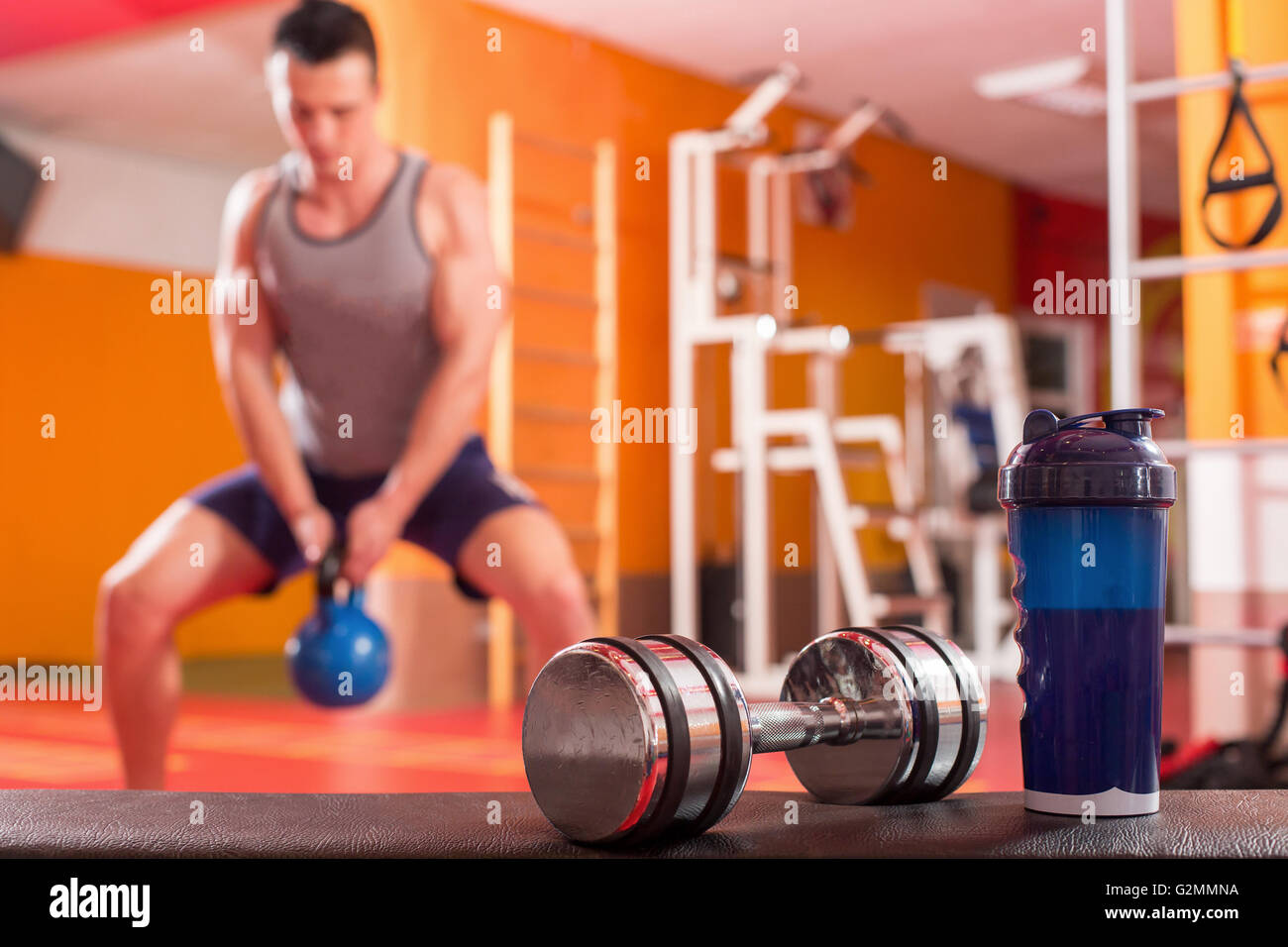 Whey protein shaker and dumbbells. Fitness and bodybuilding man in