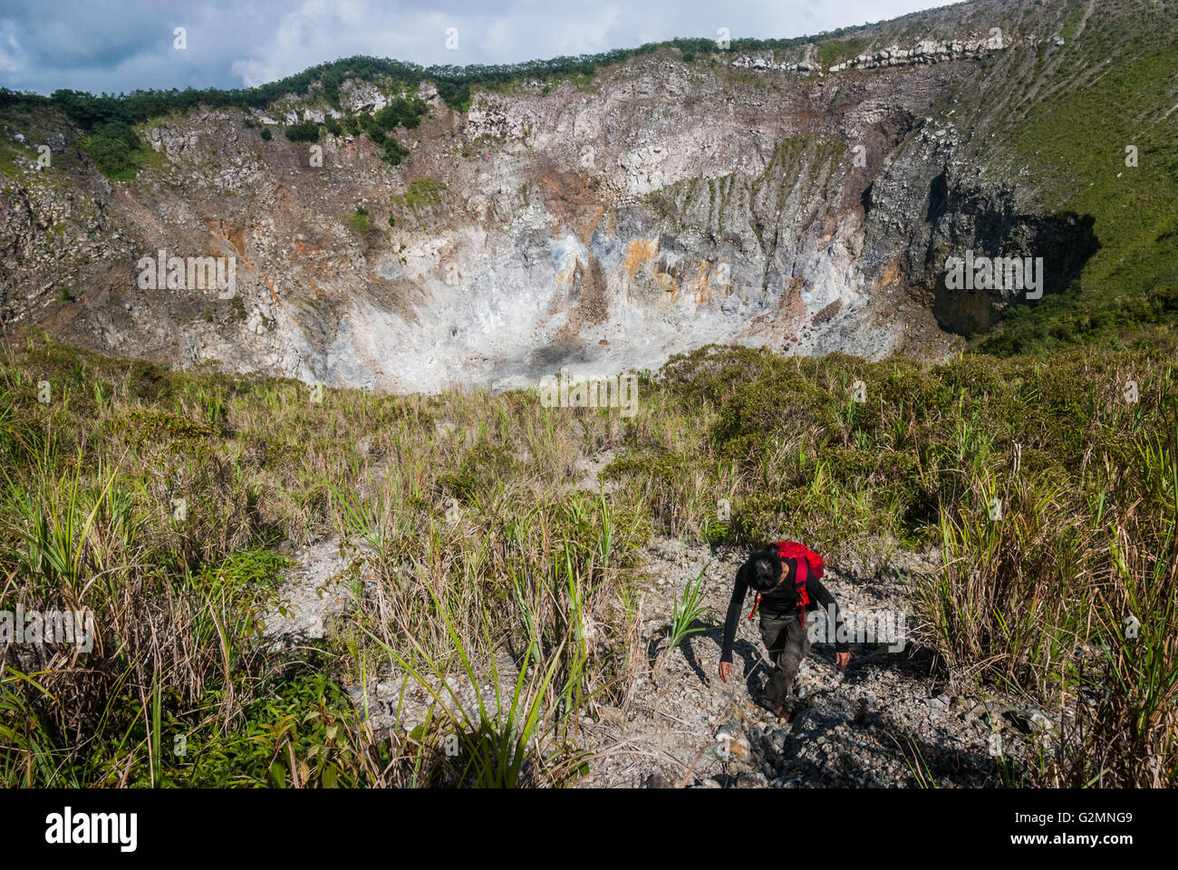 A journalist is stepping on the crater rim of Mount Mahawu volcano in Tomohon, North Sulawesi, Indonesia. Stock Photo